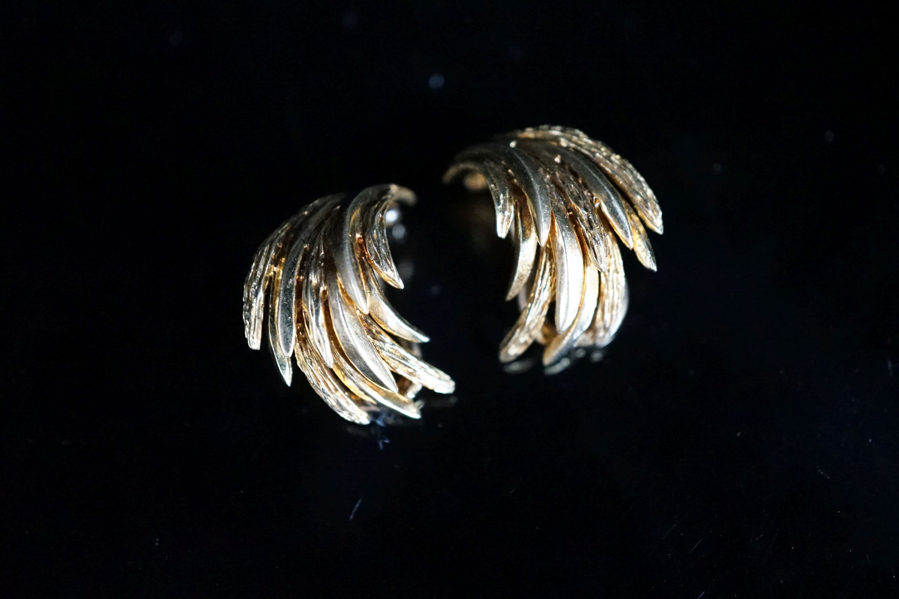 A pair of 750 yellow metal combed leaf gold ear clips, 18mm, 8.4 grams.